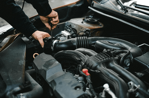 A mechanic replacing broken car parts with new ones