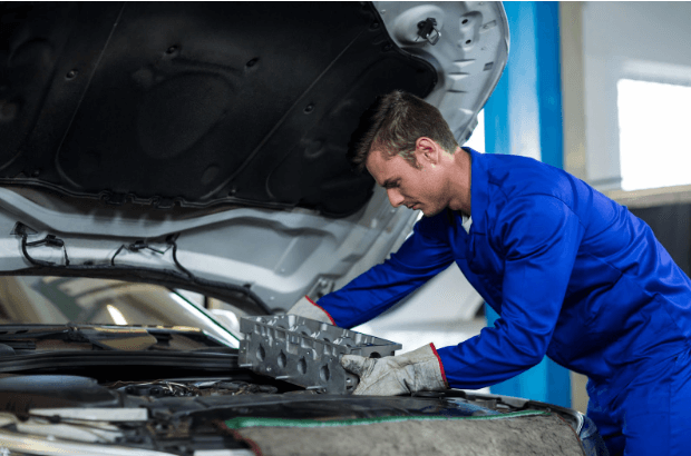 A mechanic installing used car parts.